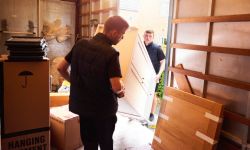 Ontruimers die meubels en dozen uit een woning verwijderen tijdens een woningontruiming